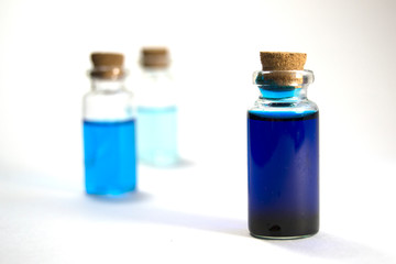 Three glass jars with blue liquid. The concept of medicine, beauty and health.