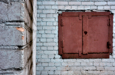 Rusty Metal Hatch on White Brick Wall