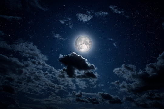 Full moon in the night sky with stars and clouds.