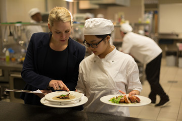 Female manager and female chefs interacting with each other