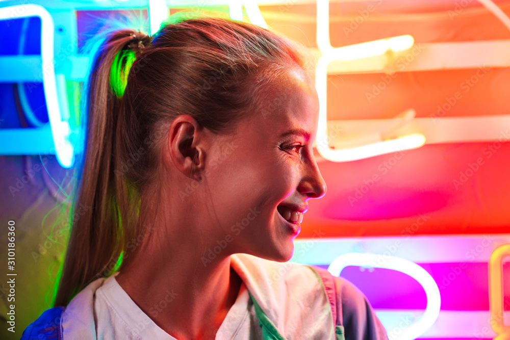 Sticker image closeup of young woman standing over multicolored neon text sign