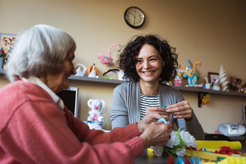 Senior woman interacting with caretaker at nursing home