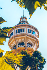 Old beautiful water tower on a background of blue sky and green park. Margaret Island, Budapest