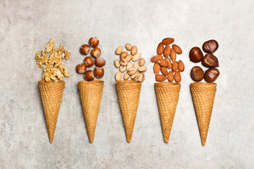 Frutos secos orgánicos con conos de helado sobre mesa gris rústica. Vista superior. Aislado