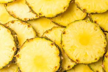 Pineapple juicy yellow slices background. Top view.