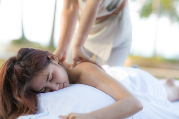 Obraz premium Asian woman getting Thai spa massage in the garden