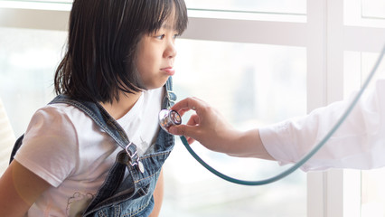 Professional general medical pediatrician doctor in white uniform gown listen lung and heart sound of Asia child patient with stethoscope: Physician check up Asian kid female after consult in hospital