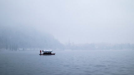Naklejka premium Isolated boats on Lake Bled in winter with a blanding background
