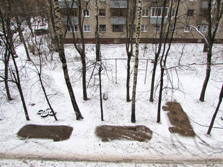  Parking spaces in winter with snow melted under the cars in the courtyard of an apartment building.