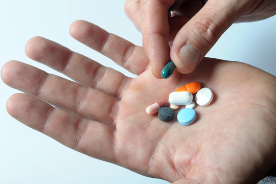 medicine in capsules and exstasy drugs and in the hands of a drug dealer