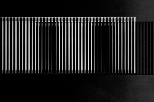 Lath structures as pattern with irregular or gently chaotic stripes resembling bar code or business architecture fragment. Abstract geometric template against black background.