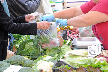 seasonal fruit and vegetables - shopping at the market - shopping - hand of the customer and seller fill the shopping bag with fruit and vegetables, economic crisis and increase in the cost of living
