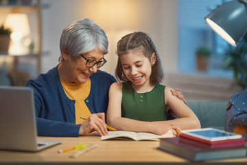Girl studying with grandma.