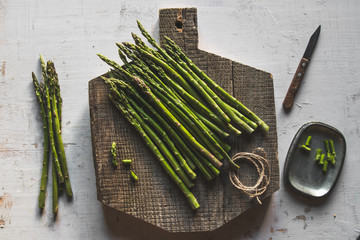 asparagus on a cut board on an old white background