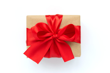 Gift box wrapped brown craft paper and red ribbon isolated on white background. Valentines day or Christmas celebration concept. Top view