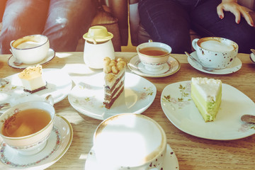 Happiness female friends meeting and drinking tea or coffee with cakes together at cafe in the afternoon. People, leisure and communication concept. Selective focus.