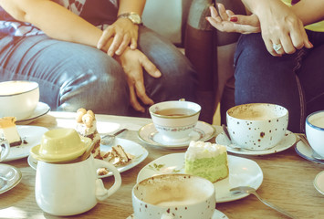 Happiness female friends meeting and drinking tea or coffee with cakes together at cafe in the afternoon. People, leisure and communication concept. Selective focus.