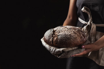 rustic bread in baker hand, healthy food - Powered by Adobe