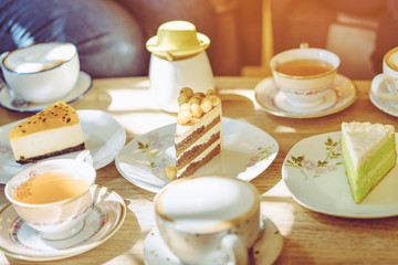 Happiness female friends meeting and drinking tea or coffee with cakes together at cafe in the afternoon. People, leisure and communication concept. Selective focus.