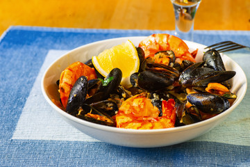 Mussels and shrimps in plate, wine.