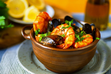 Fried shrimps and mussels in bowl, sliced lemon.