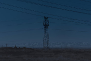 High voltage pylons on dry grassland