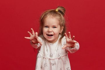 Portrait of a child. funny little girl on studio red background