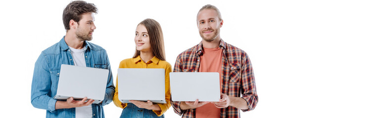 positive young friends holding laptops isolated on white, panoramic shot