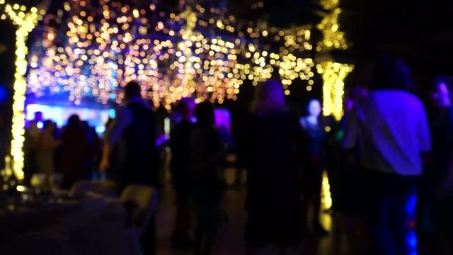 Festival event party with bokeh lights for design. Blurred dancing people.