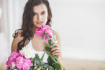 Close up portrait of young beautiful woman with flowers indoors