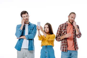 three young friends using smartphones isolated on white