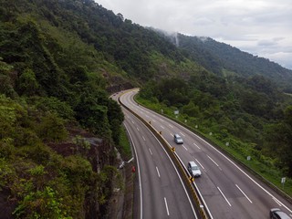 Scenic aerial view of “Lebuhraya Utara-Selatan”, a highway located in Malaysia. Highway surrounded by forest, winding road