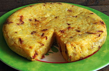 Potato omelette on a plate on wooden background