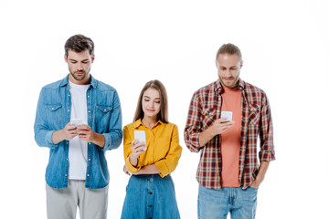 Obraz premium three young friends using smartphones isolated on white