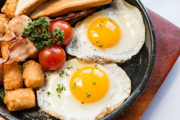 Top view,close up brunch food image of sunny side up egg skillet with vegetables.
