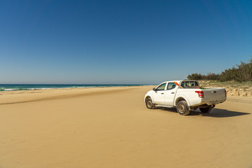 Fototapeta na wymiar there's a white pickup truck on Fraser Island beach..