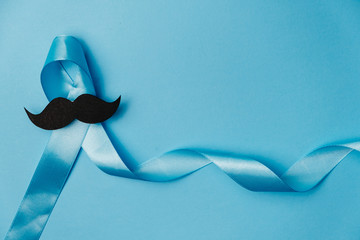 Symbol for support men. Top view on blue Ribbon with mustache for supporting people living and...