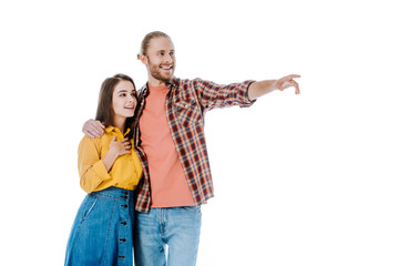 happy young couple in casual outfit pointing with finger away isolated on white