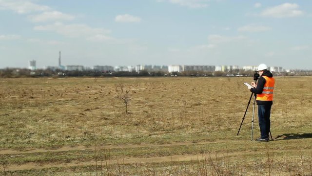 Surveyor worker measures the distance and length using measuring equipment for the construction of a new micro district, copy space