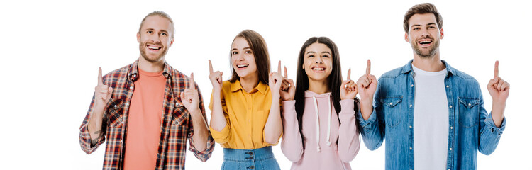 happy multicultural friends pointing with fingers up isolated on white, panoramic shot