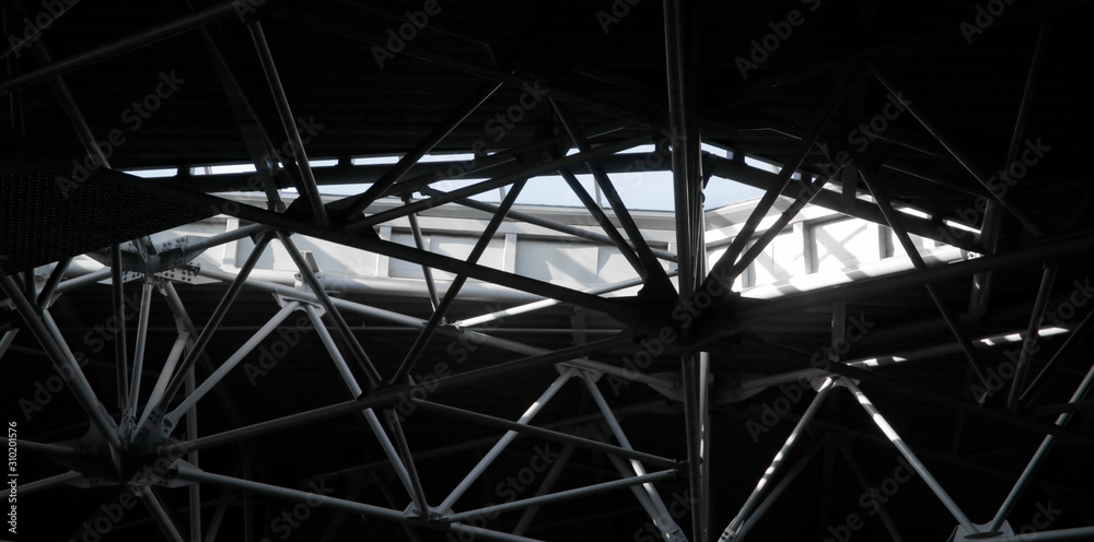 Poster close-up of industrial building interior fragment. louvered metal surface and ceiling framework. gru