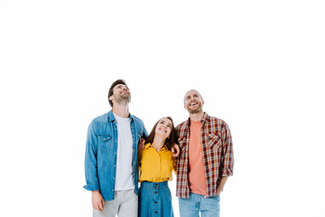 three happy young friends looking up isolated on white