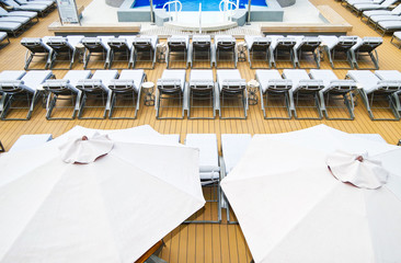 Empty Pool Deck onboard luxury cruise ship liner with whirlpool, sun loungers beds, swimmingpool,...