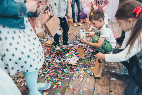 Broken piñata. Children collecting  sweets from the floor.