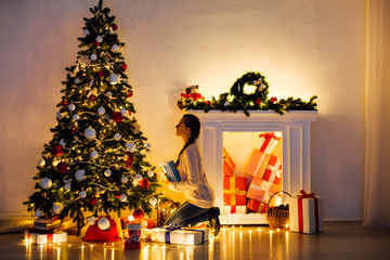 beautiful woman decorates the Christmas tree Garland lights new year holiday