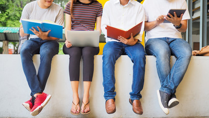 Student groups are viewing information in books and laptops. Willing to study together