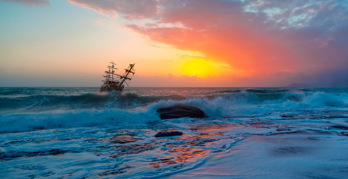 Sailing old ship in stormy sea in the background dramatic sunset "Elements of this image furnished by NASA"