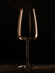Wine glass on a dark colored background. Glare in the glass, minimalistic beautiful concept