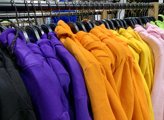 Bright women's clothing on hangers in a fashion store. Stylish winter clothes for women.