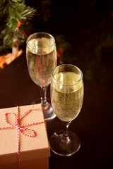 Two glasses of champagne and gift box on the dark background